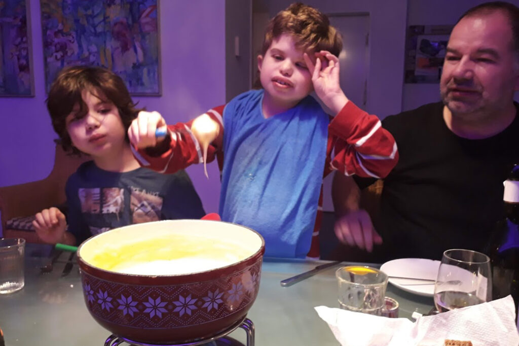 Max isst mit seinem Bruder und seinem Vater Fondue