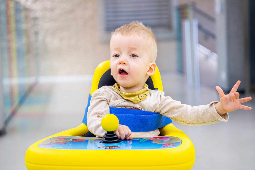 kleiner Junge sitzt im Elektrorollstuhl Mini Explorer für Kleinkinder